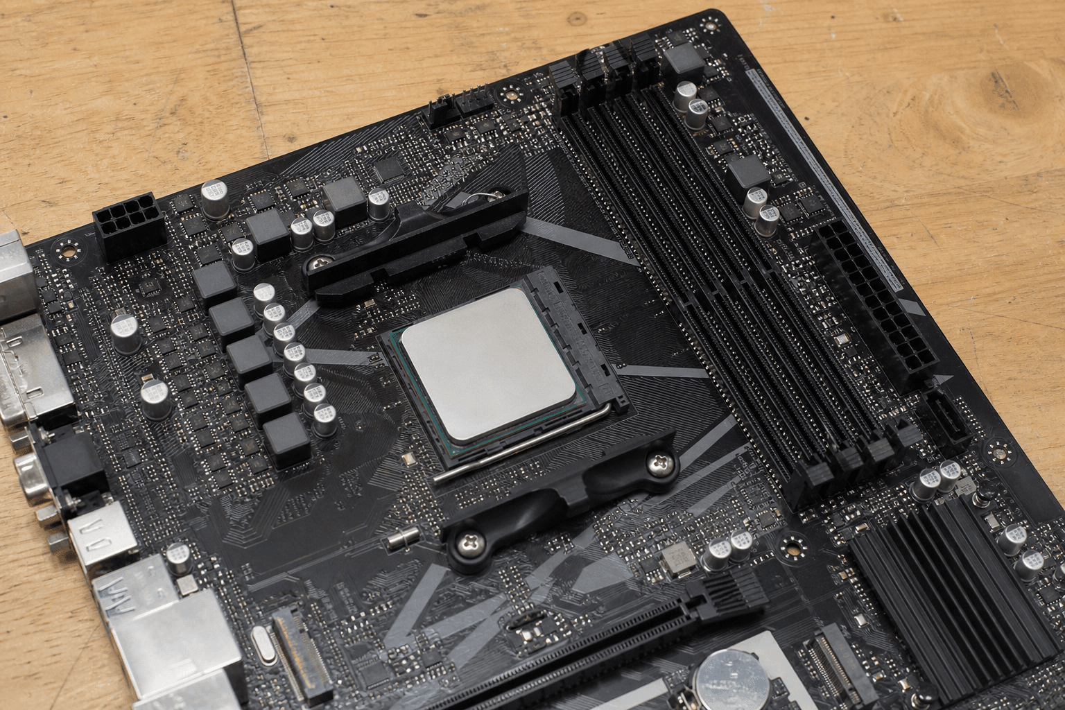 Älteres AM4-Mainboard mit eingesetztem Prozessor auf einer Werkbank